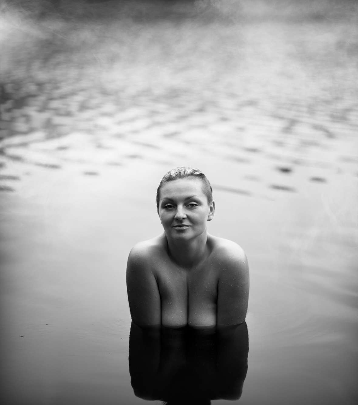 nude woman in the water up to her chest black and white